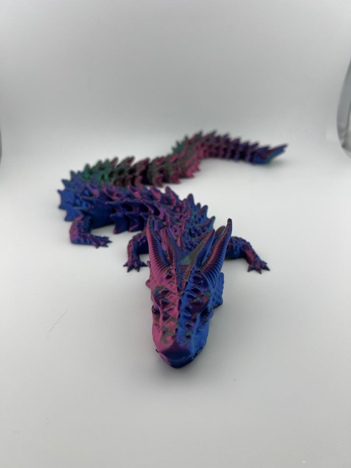 Multicolor articulated Shadow Dragon with tall horns and spiked scales in purple, blue, and green